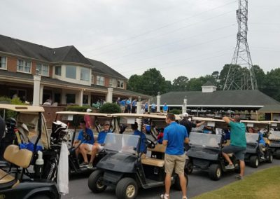 A lineup of about 10-15 golf carts and caddies.