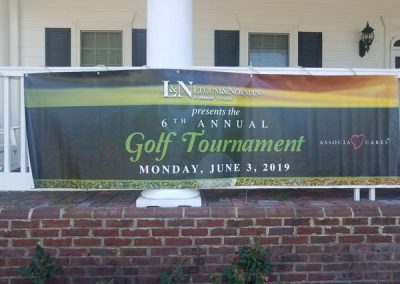 A sign that says "L&N Legum & Norman, an Associa Company presents the 6th Annual Golf Tournament, Monday, June 3, 2019"
